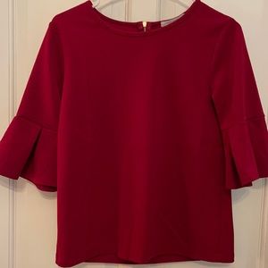 Red shirt with ruffle sleeves.